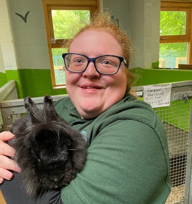 A woman holding a black rabbit at Pets' Corner