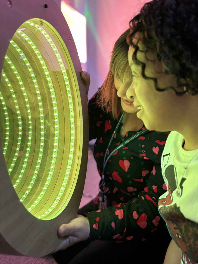 Child interacting with a glowing sensory light panel