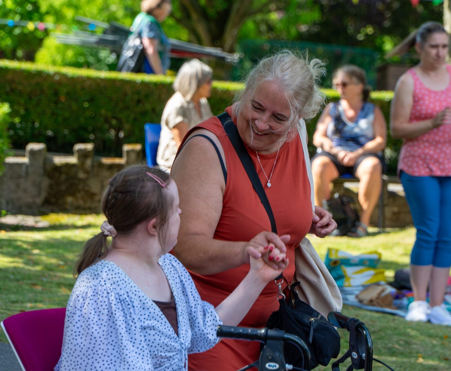 A support worker and supported person holding hands
