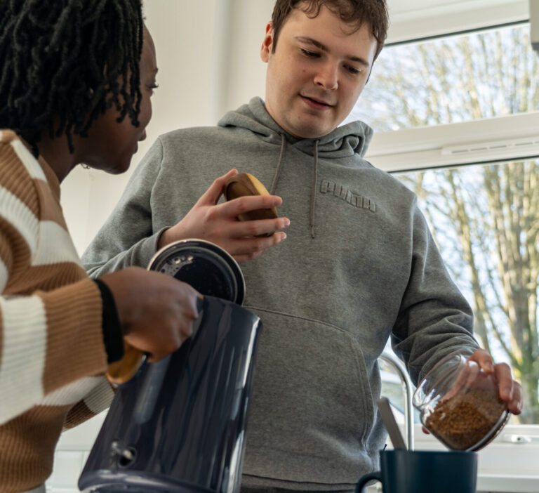 a woman supporting a man to make a coffee