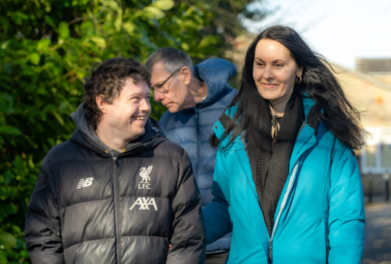 Group of adults smiling together while walking outdoors