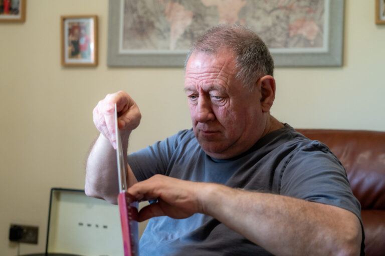 A man focusing on taking papers out of a folder
