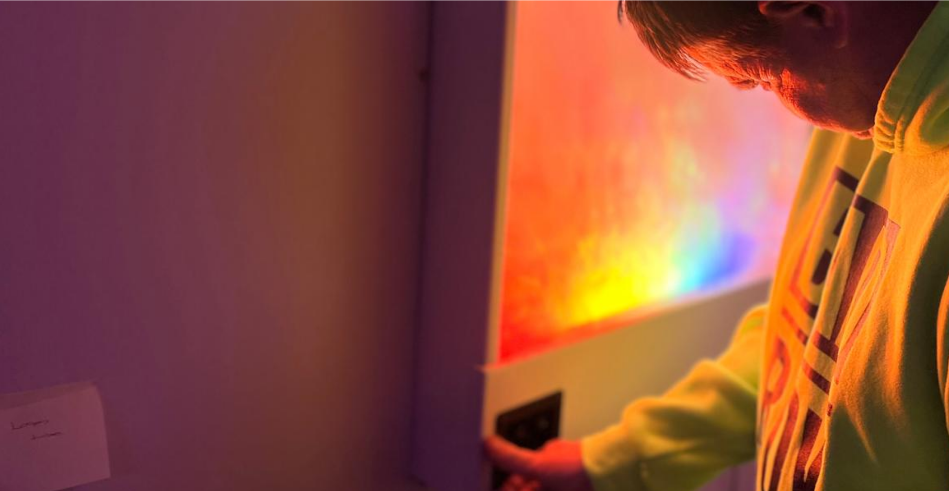 Person interacting with a colour changing sensory wall panel