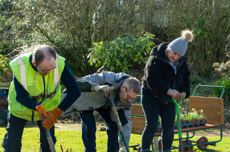 Two men planting or tending plants during a gardening session