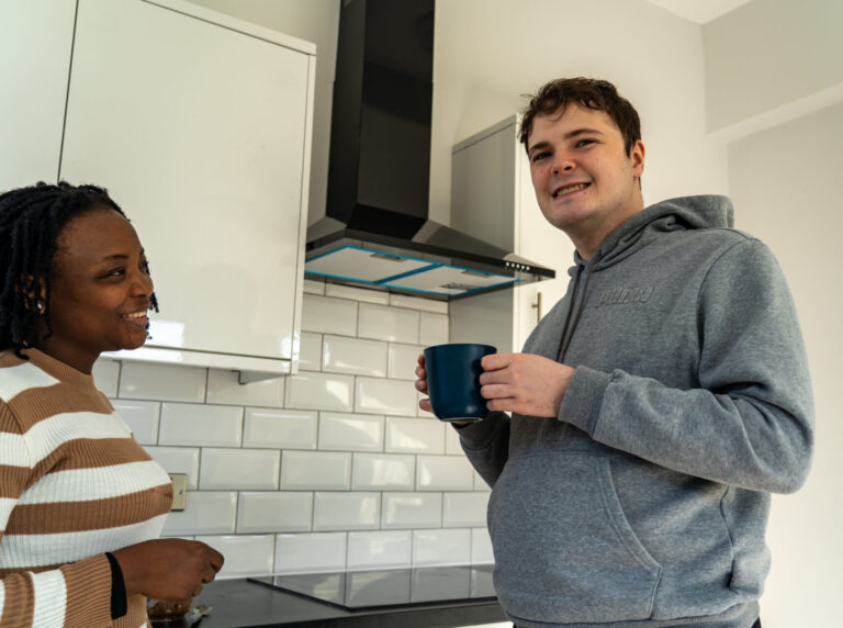 A happy man and a woman standing in a kitchen