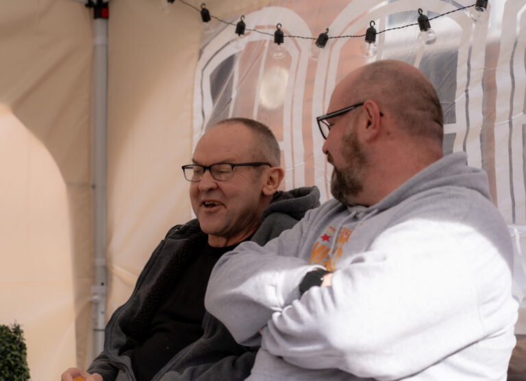 two men sat together laughing