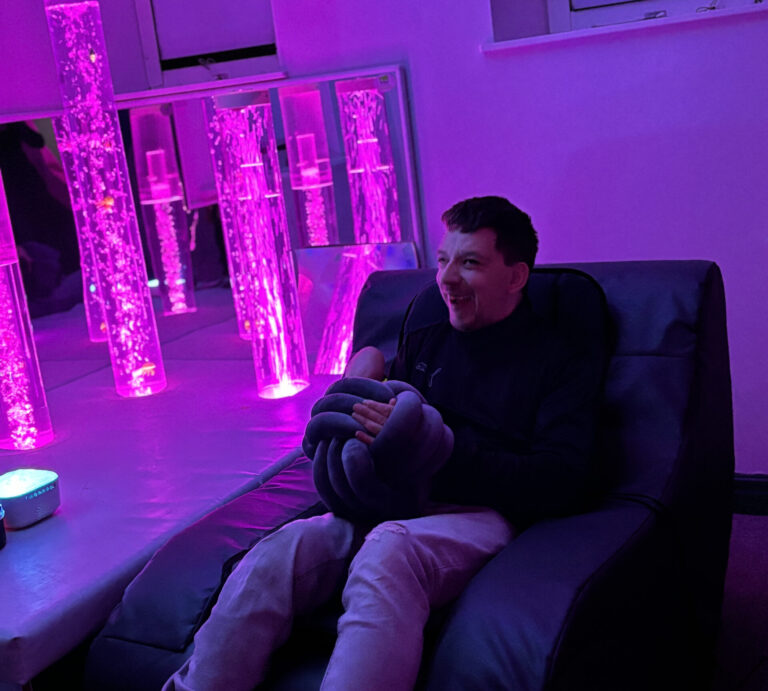 Adult relaxing on a sofa in a sensory room